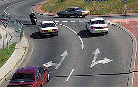 When turning left at a roundabout you should enter and leave the roundabout -